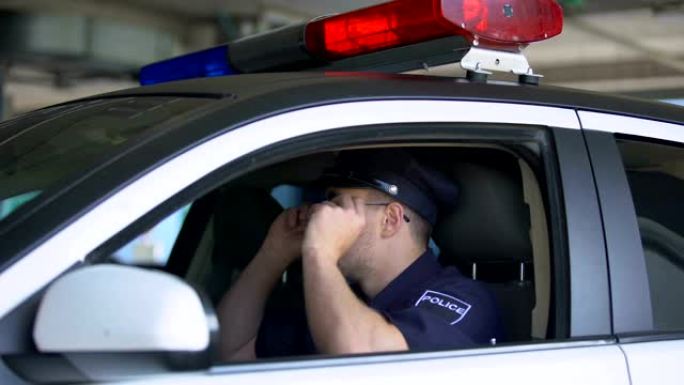 自信的警察戴着墨镜在车里，准备进行区域巡逻、工作