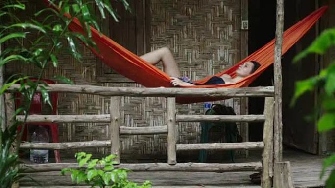 女人躺在丛林小屋的吊床上