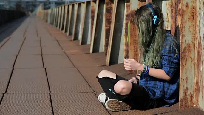 带耳机的女孩女孩坐路边听音乐有线耳机自我