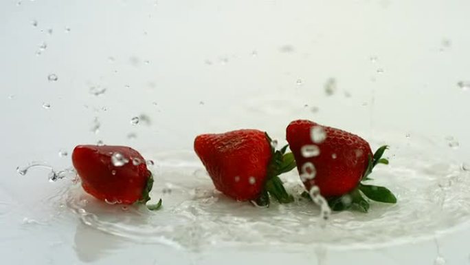草莓飞溅，慢动作清澈水滴溅落