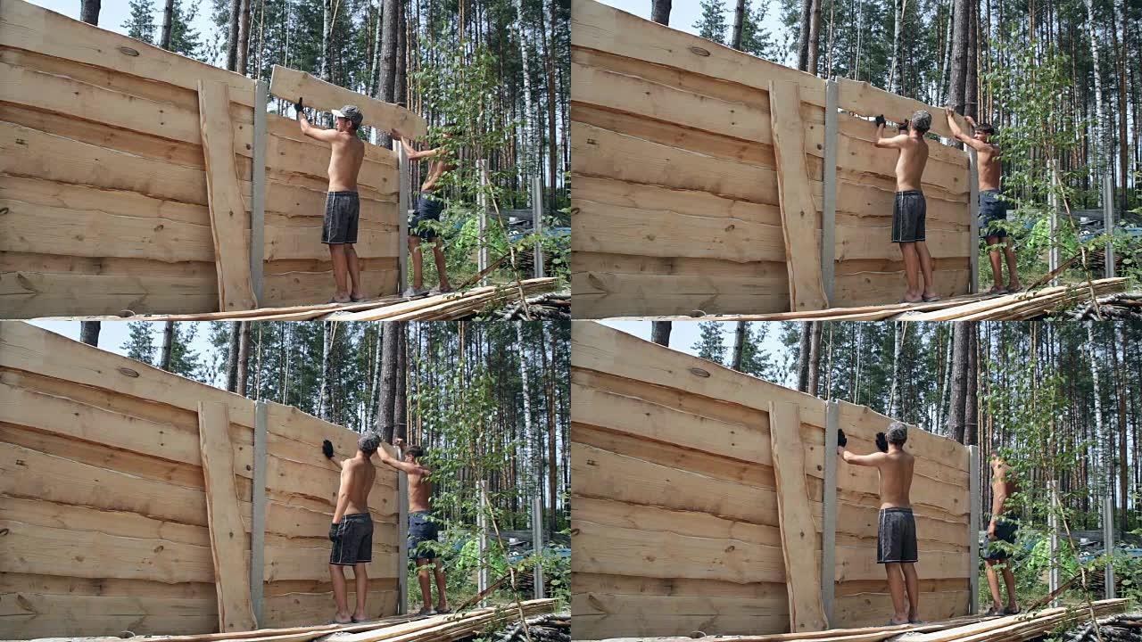 建筑商制作木栅栏。