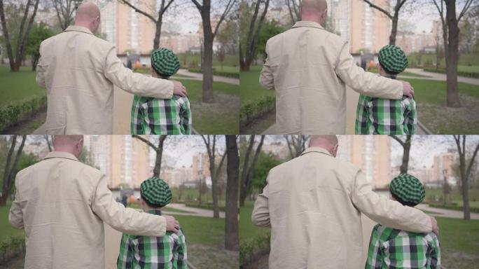 祖父和孙子背对着镜头在公园散步的肖像背影。
