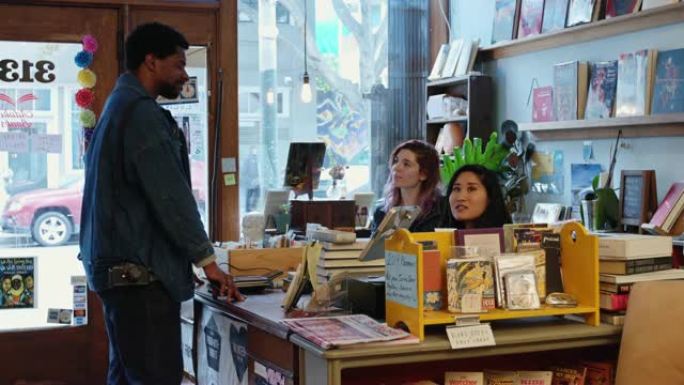 微笑的书店工人向客户卖书