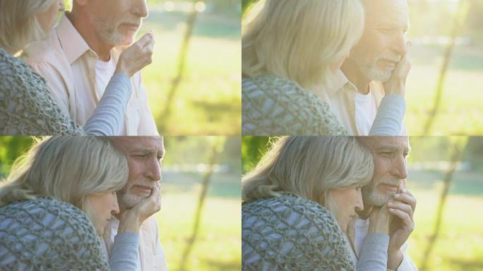 老妇人支持和拥抱她生病哭泣的丈夫，坏消息，绝望