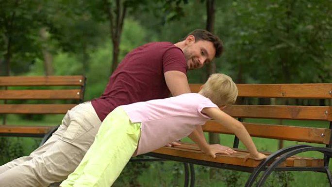 父亲教儿子在长凳上做俯卧撑，积极的生活方式和运动，家庭