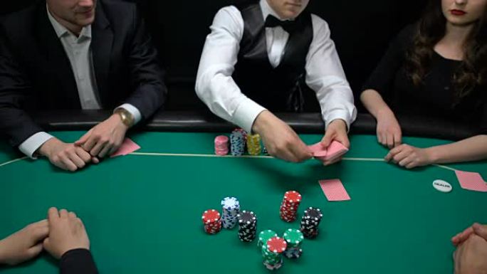 玩家投注和扑克经销商在赌场桌上打开社区卡