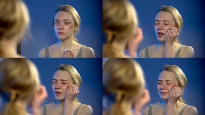 哭泣的年轻女子在镜中消毒脸部伤口，问题绝望