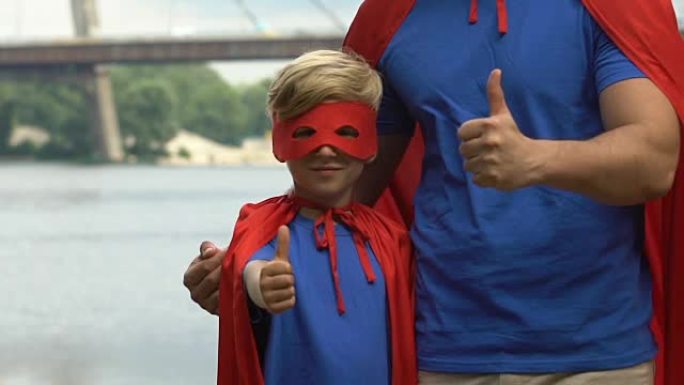 穿着超人服装的儿童艺人和男孩在休闲中心竖起大拇指