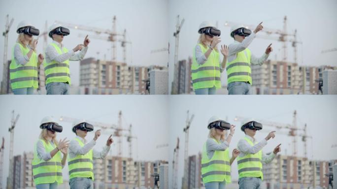 两个男人和女人戴着虚拟现实眼镜在正在建造的建筑物的背景上起重机。用手模仿界面进行设计的经理和助手