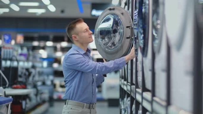 一个年轻英俊的男人在消费电子商店为他的新家选择一台智能洗衣机。研究特征