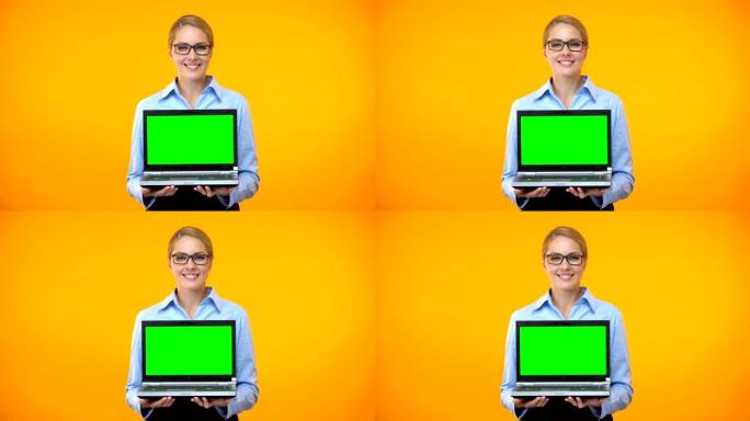 快乐的年轻女子拿着绿屏笔记本电脑，启动演示，应用程序