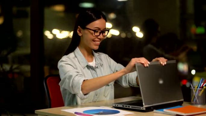 疲倦的女人在笔记本电脑上完成工作，对工作效率感到满意