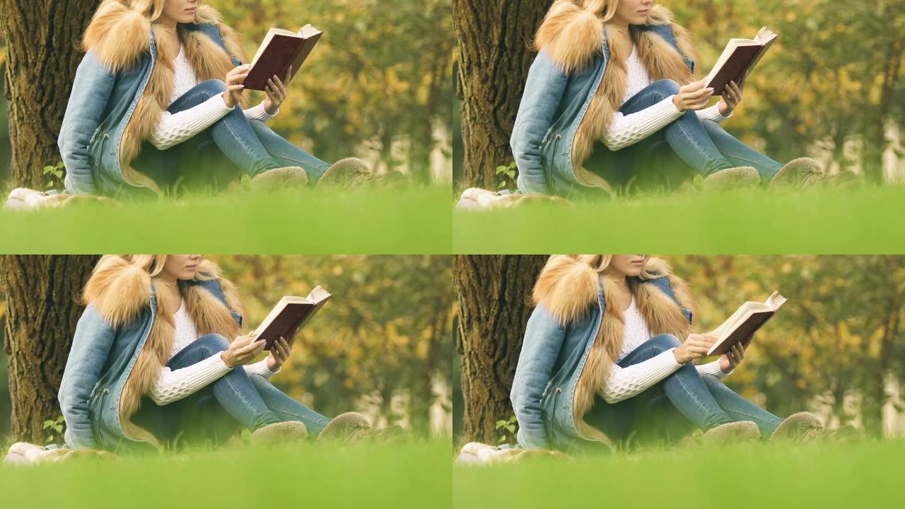 女学生在公园看书，在新鲜空气中愉快的消遣，放松