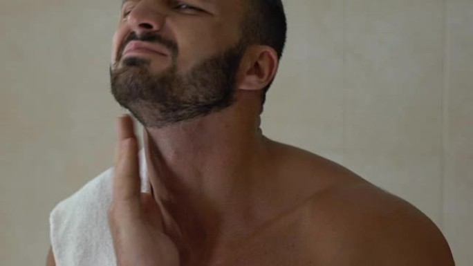 男士在浴室使用剃须后的乳液，刺激灼烧的皮肤，化妆品