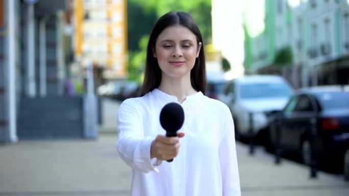 女记者提议麦克风，在街上接受采访，每日新闻