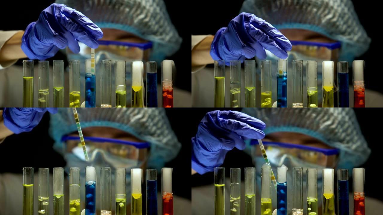 科学家在黑暗的实验室中测量带有蓝色液体的试管中的酸度水平