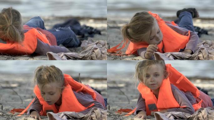 小女孩穿着救生衣在海边吐水，沉船幸免于难
