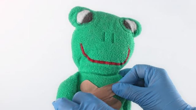 SLO MO LD医生在毛绒青蛙玩具上放了第二个粘性绷带