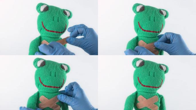 SLO MO LD医生在毛绒青蛙玩具上放了第二个粘性绷带