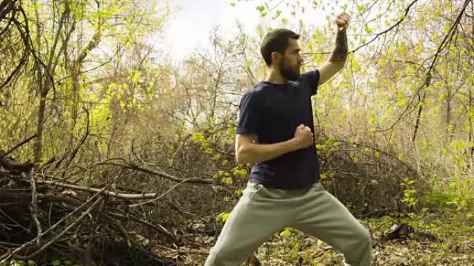 年轻人在春天的森林里练习空手道。
