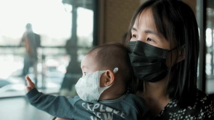 妈妈抱着儿子，戴着空气污染面具