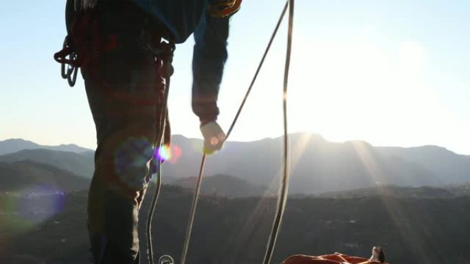 男性登山者在山顶上组织绳索