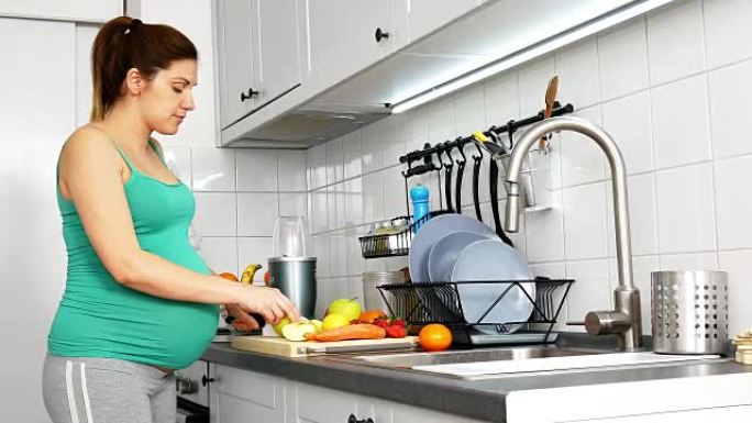 千禧九个月的孕妇在家，在厨房准备果汁