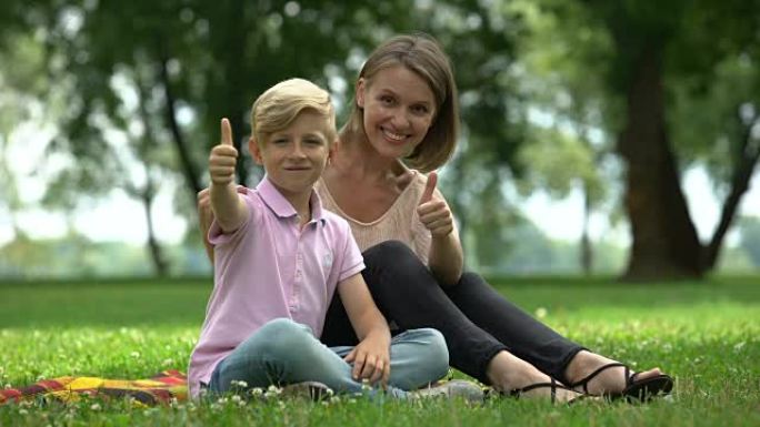 快乐的女人和男孩竖起大拇指，为单身母亲提供社会支持的广告