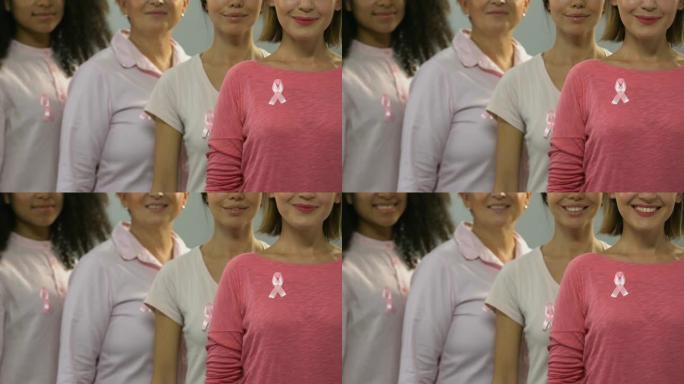 一群带着粉红丝带的健康女性对着镜头微笑，进行抗癌运动