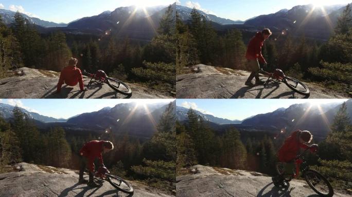 男性山地自行车手在日出时在岩石板上放松