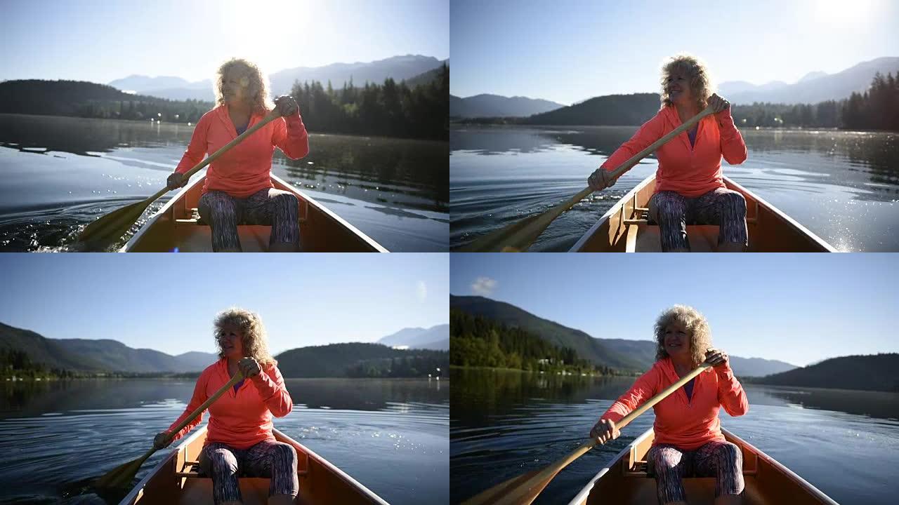在原始湖上划独木舟的高级妇女