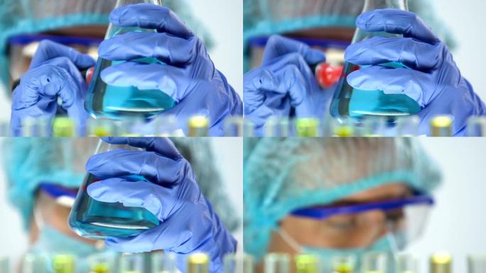 实验室化学家标记烧瓶用蓝色液体，家用化学品生产