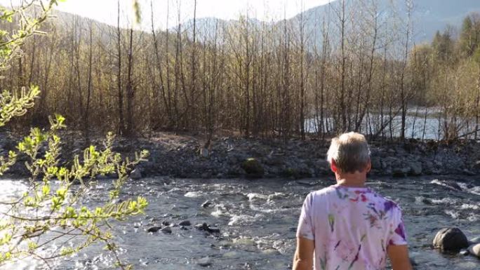 成熟的男人在日出时沿着海岸线行走