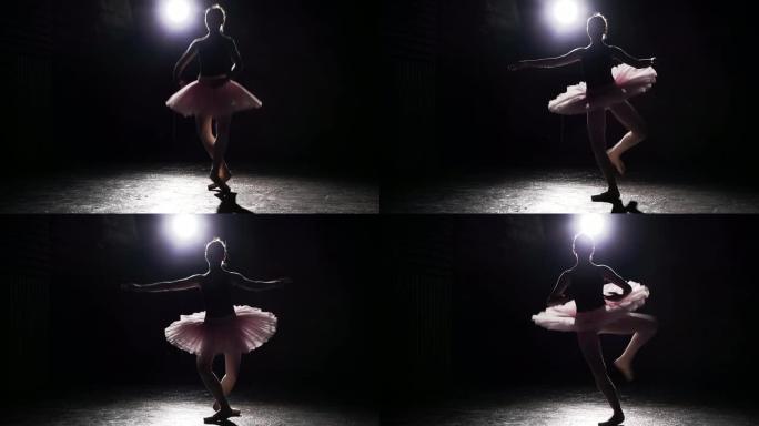 美丽的年轻优雅芭蕾舞演员在黑色混凝土地板背景的足尖鞋上。芭蕾舞练习。慢动作。