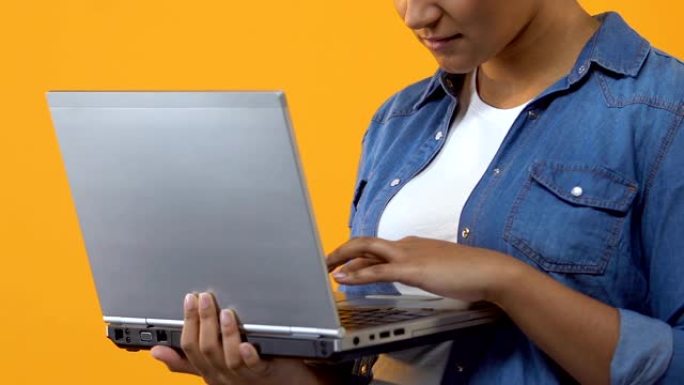 女性自由职业者在黄色背景上打字笔记本电脑键盘，博客帖子