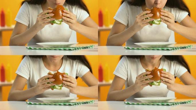 女性在快餐店吃食欲旺盛的脂肪汉堡，饮食，肥胖