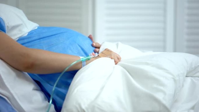 孕妇拿着毯子，感觉腹痛，有流产风险