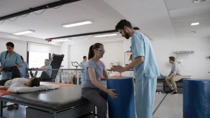 一组拉丁美洲患者在诊所进行物理治疗时与他们的治疗师一起锻炼