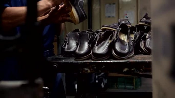 无法识别的人在工厂检查成品鞋的任何缺陷