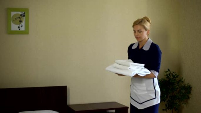 友好的酒店工作人员展示干净的枕头、良好的客房服务、健康标准