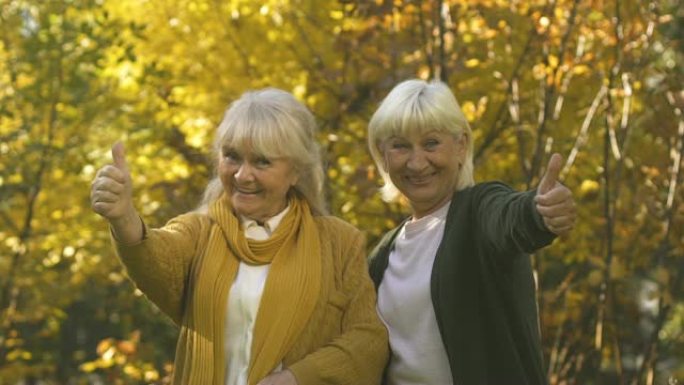 快乐的老妇们竖起大拇指，享受养老金领取者的福利，慢动作