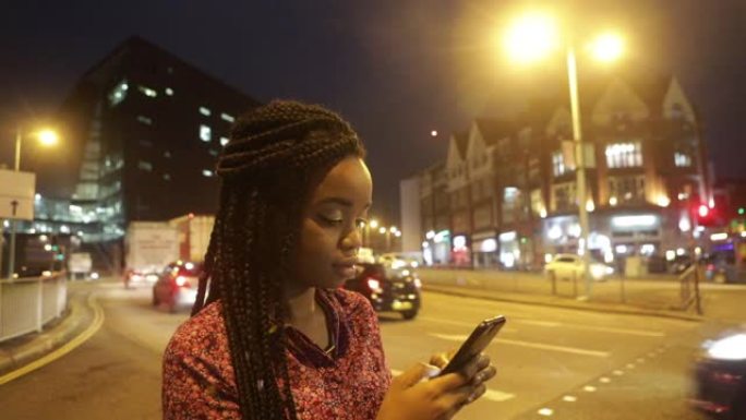 晚上，年轻女子在街角发短信