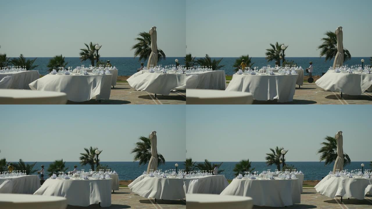 准备露天派对: 香槟酒杯和餐巾纸在圆桌上装饰白色桌布