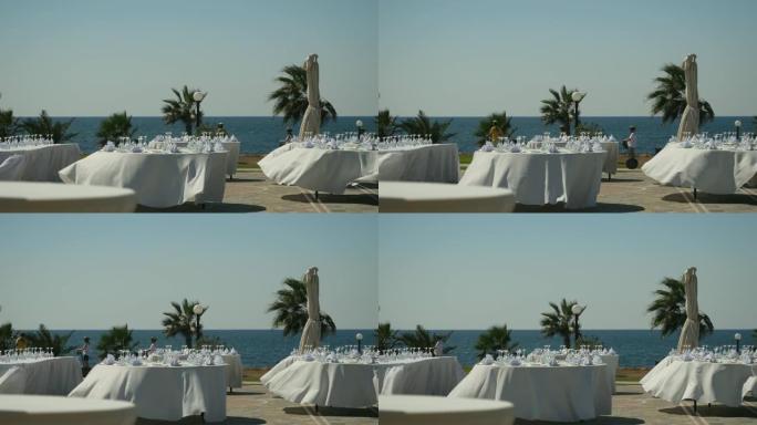 准备露天派对: 香槟酒杯和餐巾纸在圆桌上装饰白色桌布
