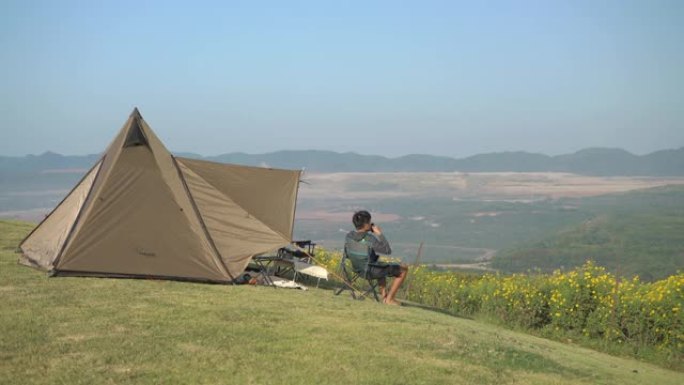 男子在露营旅行中看着山脉喝咖啡