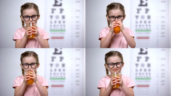 积极的小女孩喝胡萝卜奶昔，健康营养，眼部维生素