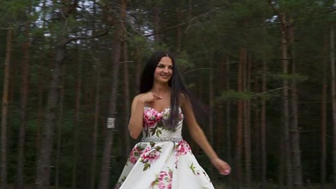 穿着长裙的美丽女孩在森林的背景下旋转