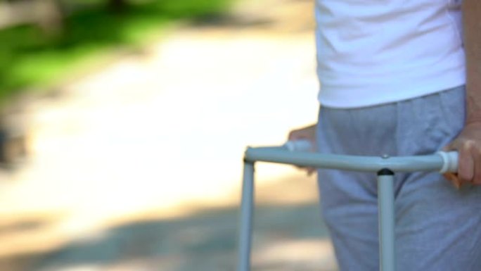 老年妇女用步行架搬到户外，膝关节置换手术