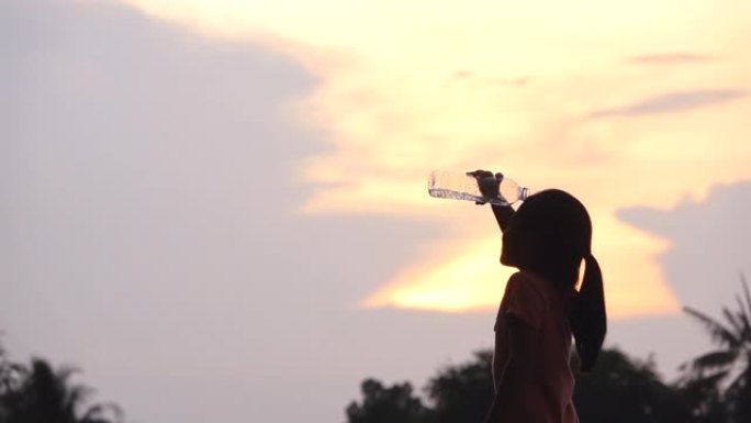 亚洲小女孩在公园快乐地喝水，慢动作