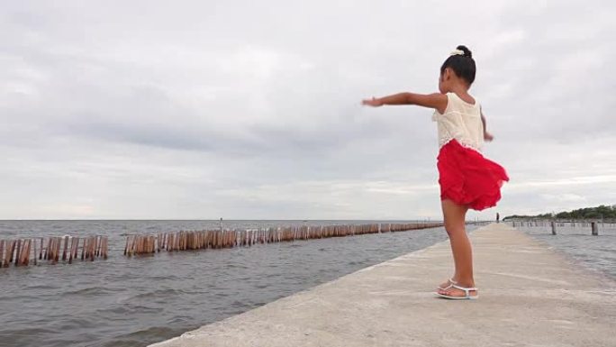 慢动作亚洲女孩在海边跳舞。